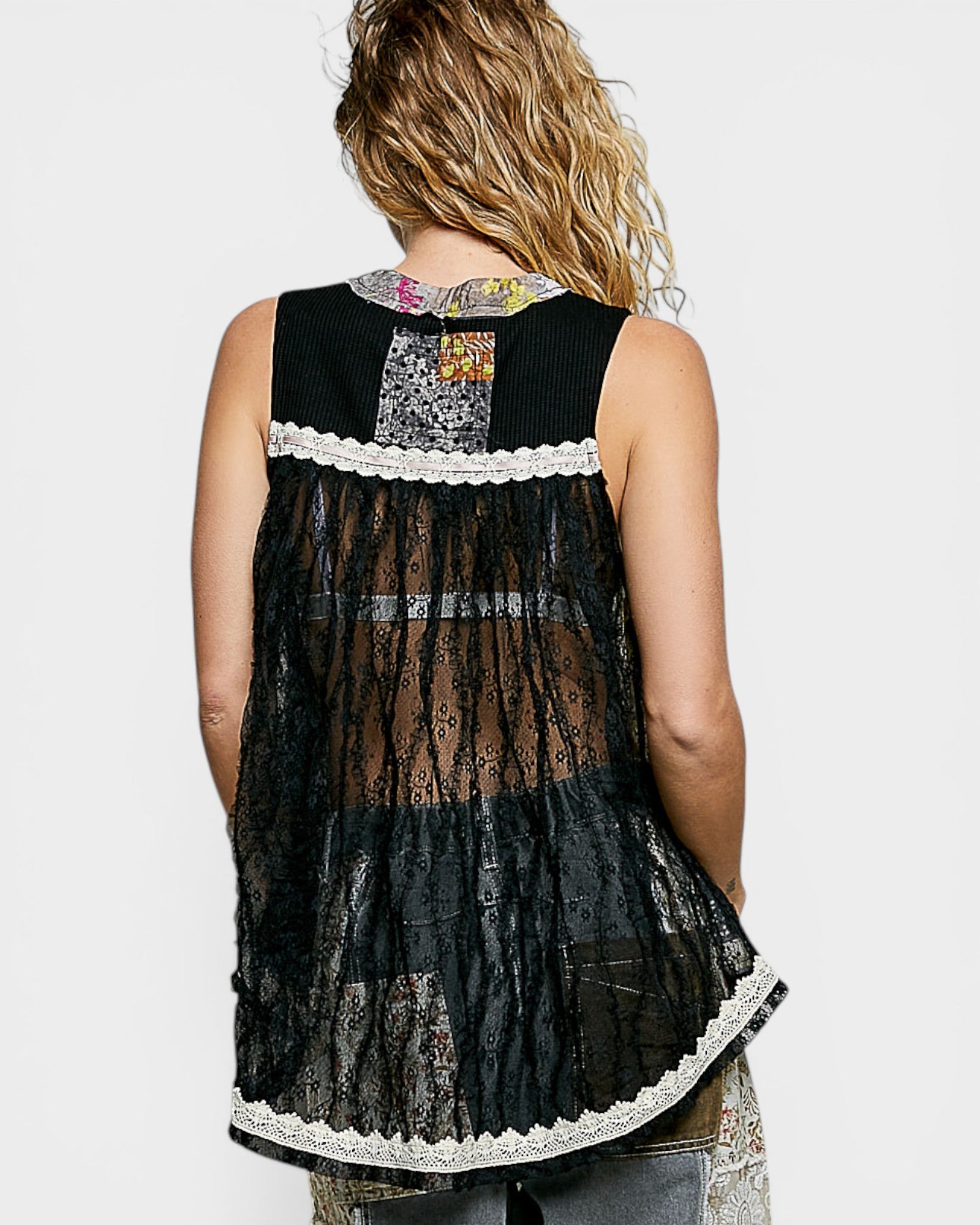 Black sleeveless top with lace details on a plain background