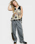 Woman wearing a patchwork top and jeans on a white background