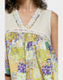 Colorful floral dress with a white lace trim on a plain background