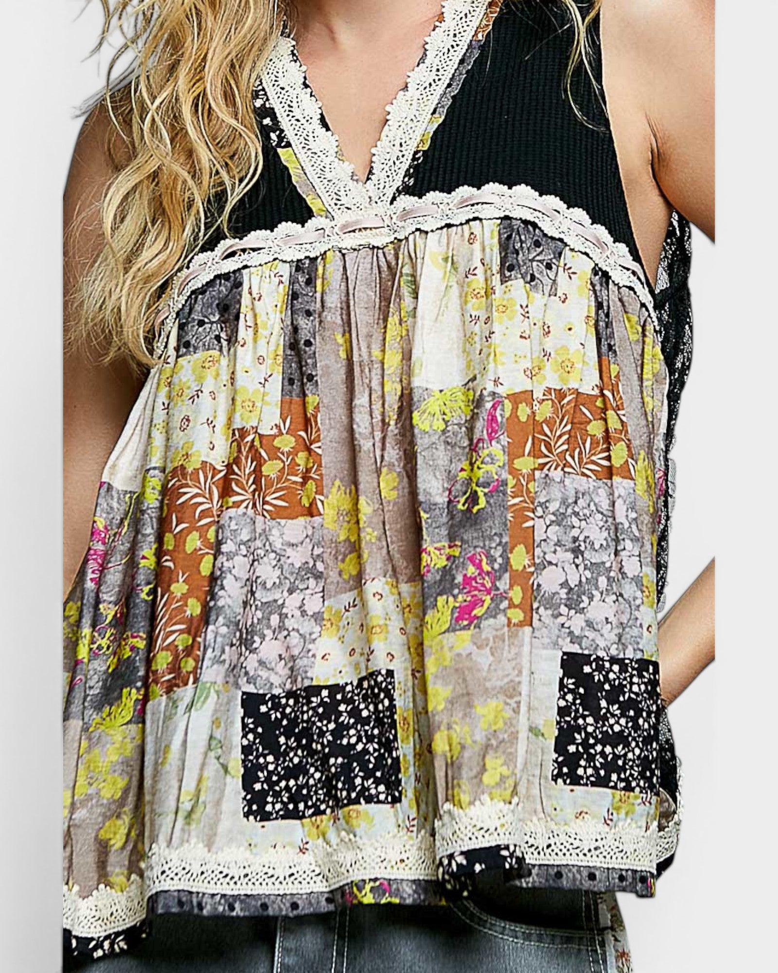 Multicolored floral patterned top with lace trim on a plain background