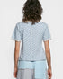 Person wearing a light blue patterned top with matching pants on a white background