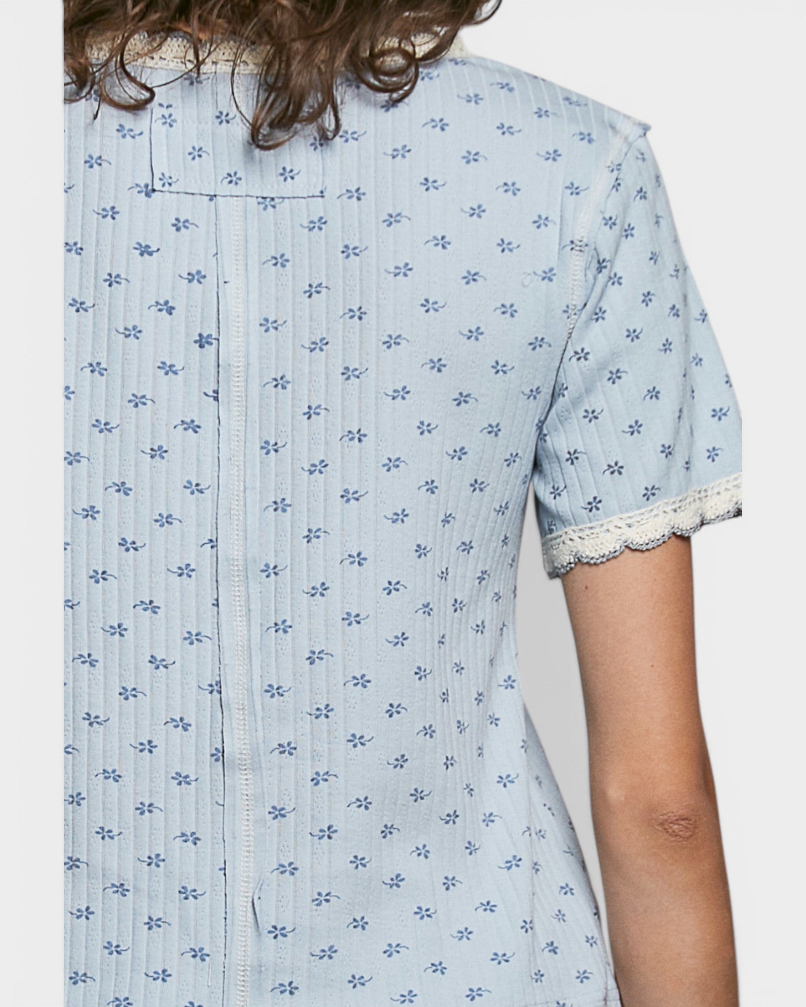 Light blue floral patterned shirt worn by a person on a plain background