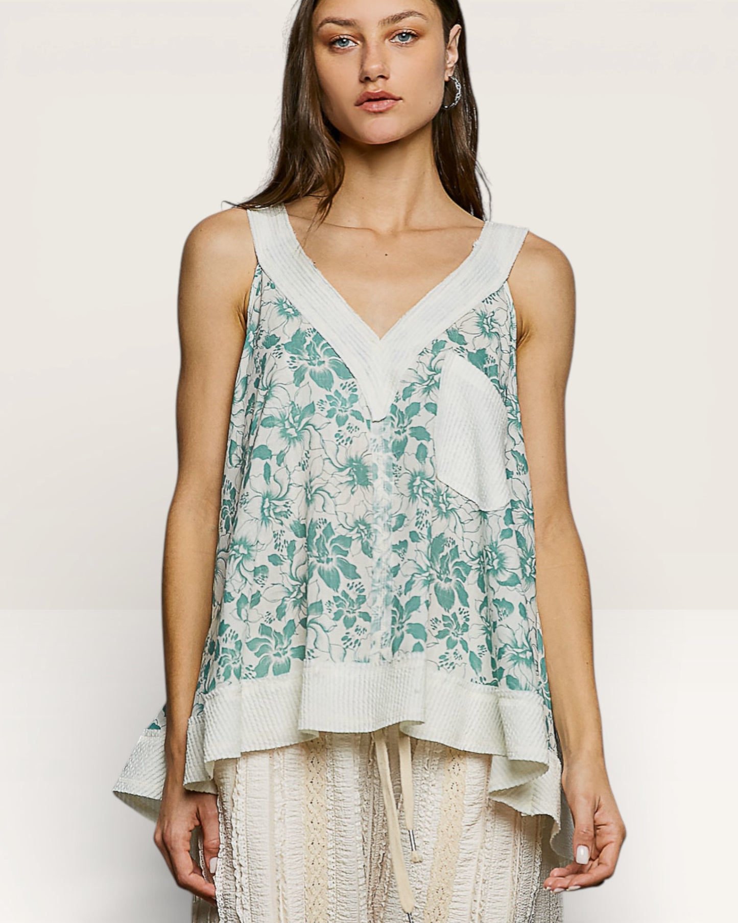 Woman wearing a floral sleeveless top with a plain background