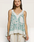 Woman wearing a floral sleeveless top with a plain background