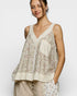 Woman wearing a floral sleeveless top with a plain white background