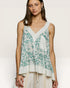 Woman wearing a floral sleeveless top with a plain white background