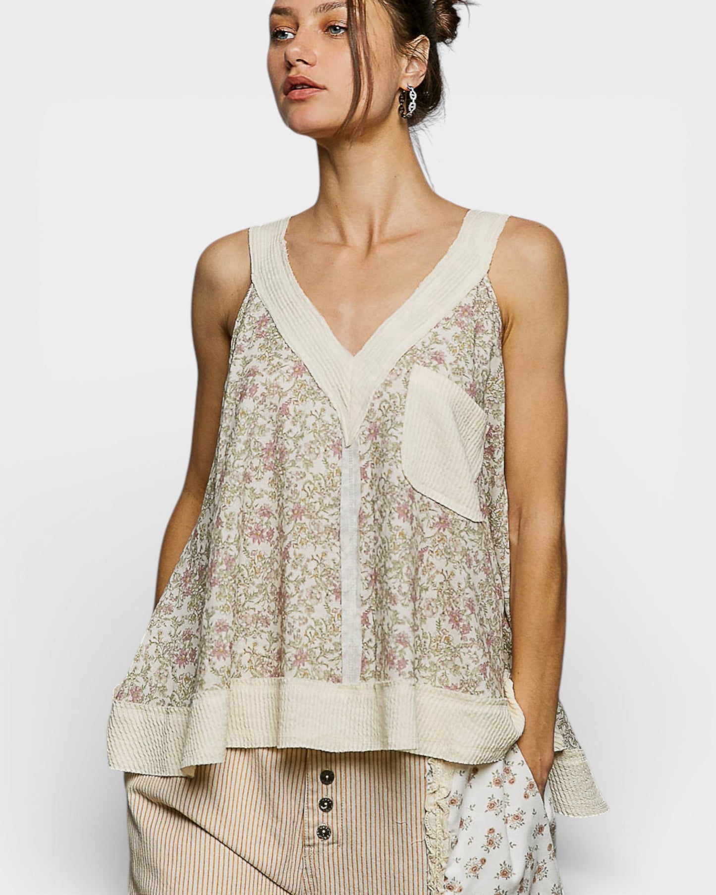 Woman wearing a floral sleeveless top with a plain background