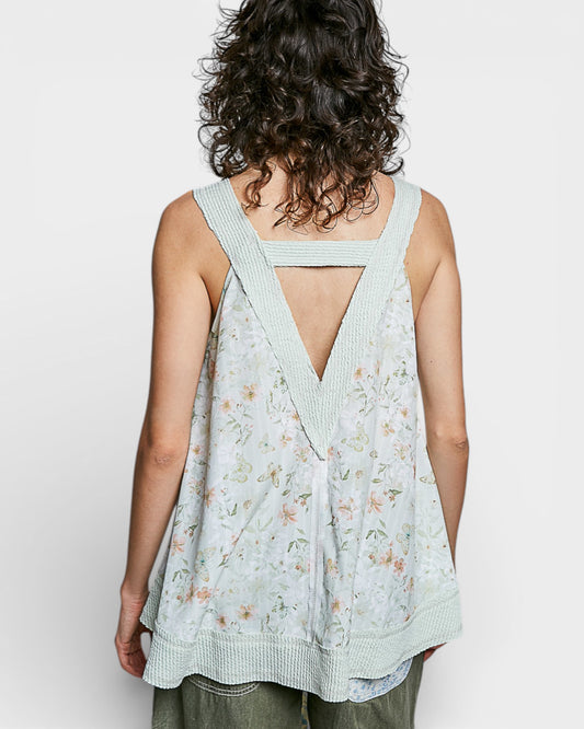 Woman wearing a light blue floral dress with a V-neckline on a white background