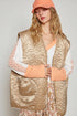 Woman wearing a beige quilted vest over a floral dress with a plain background