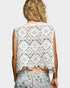 Person wearing a white lace top with a plain background
