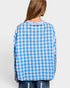 Person wearing a blue and white checkered shirt on a plain background