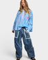 Person wearing a blue checkered shirt and blue jeans on a white background