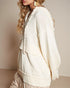 Person wearing a cream-colored hoodie with a neutral background
