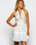 Woman wearing a white lace dress against a plain background
