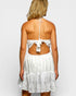 White lace dress with open back worn by a person on a plain background