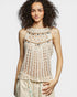 Woman wearing a beige crochet top against a plain background