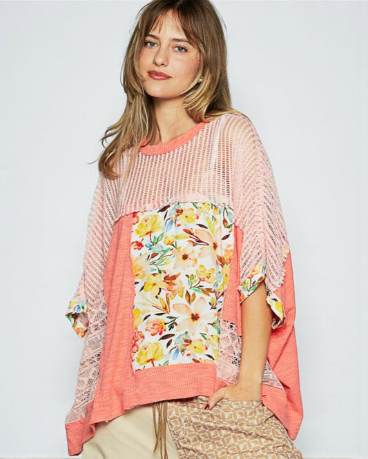 Woman wearing a pink and floral patterned top on a white background