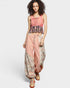 Woman wearing a pink top and patterned pants on a white background
