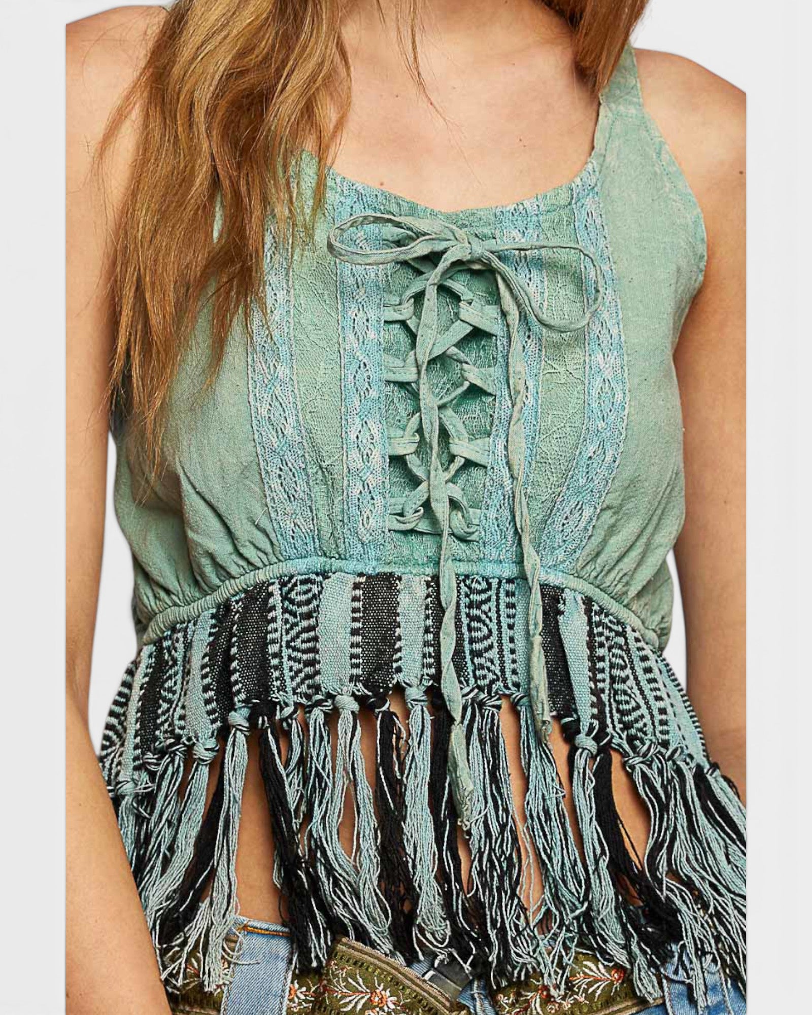 Green lace-up top with fringe details on a white background