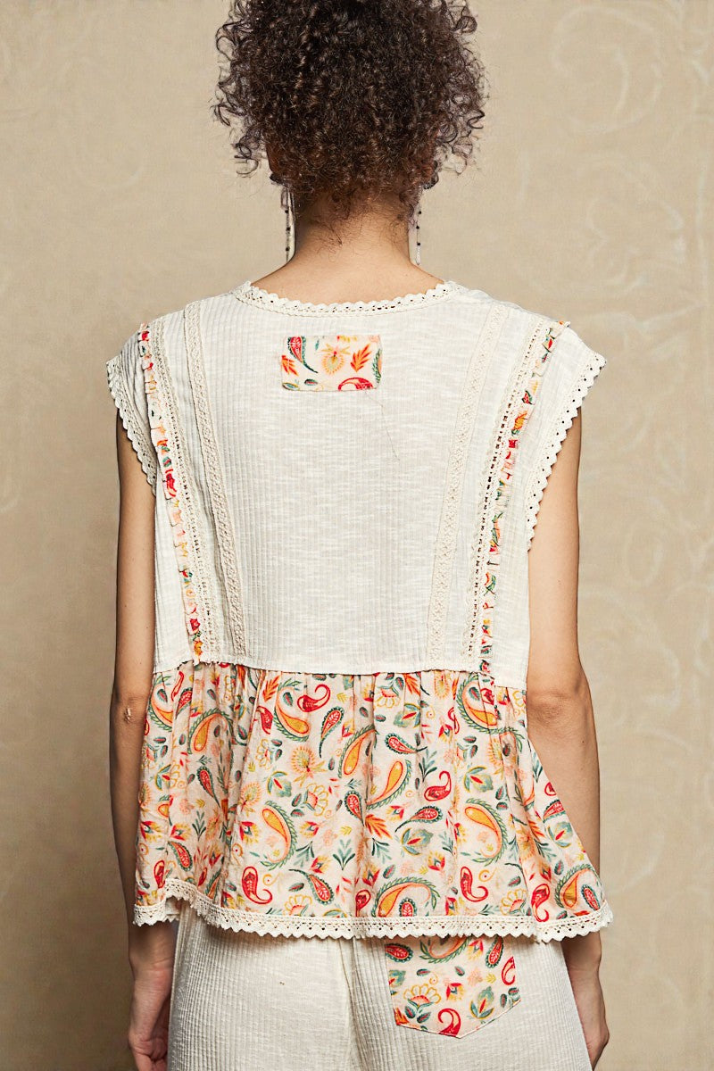 Woman wearing a white top with colorful floral patterns on a beige background