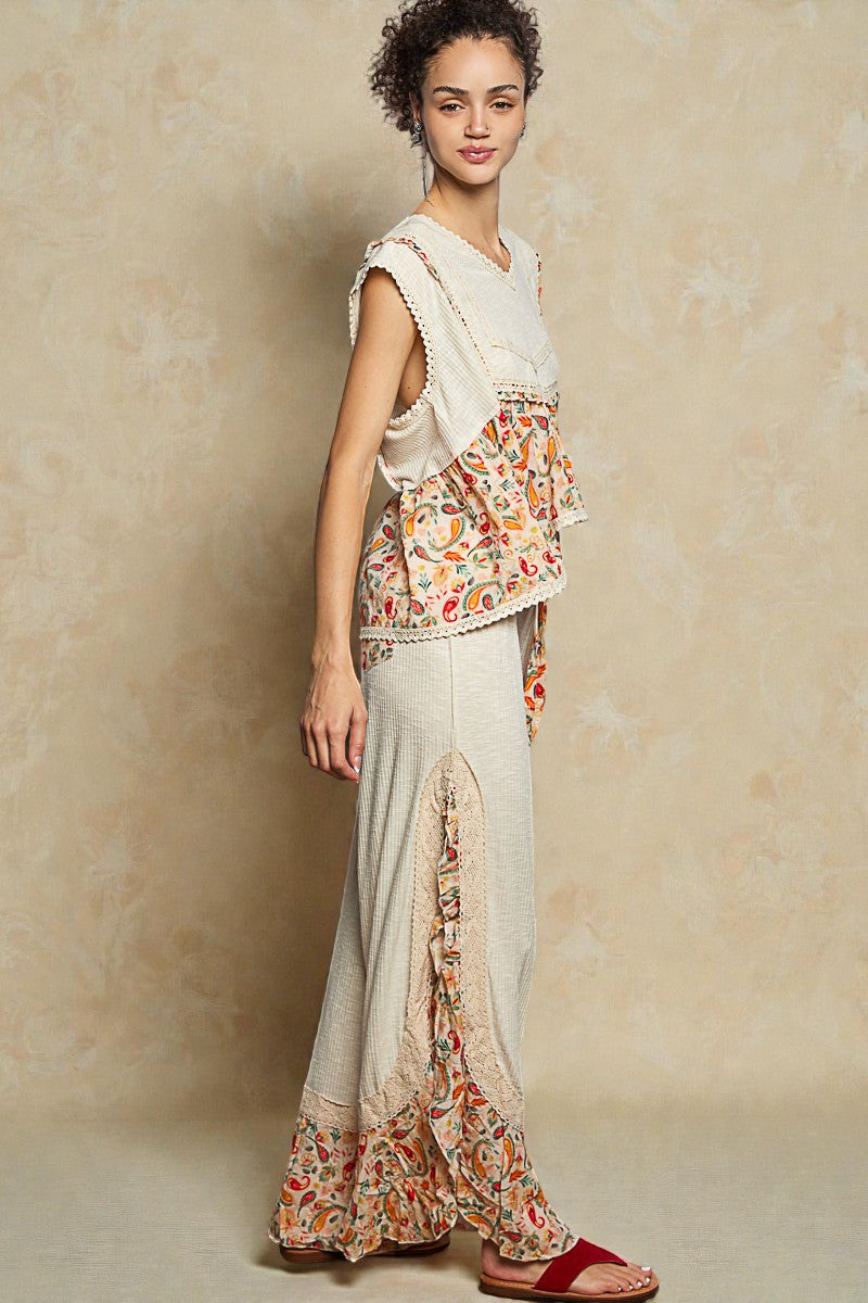 Woman wearing a floral top and skirt with a plain background