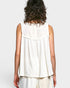 Person wearing a white sleeveless top on a plain background