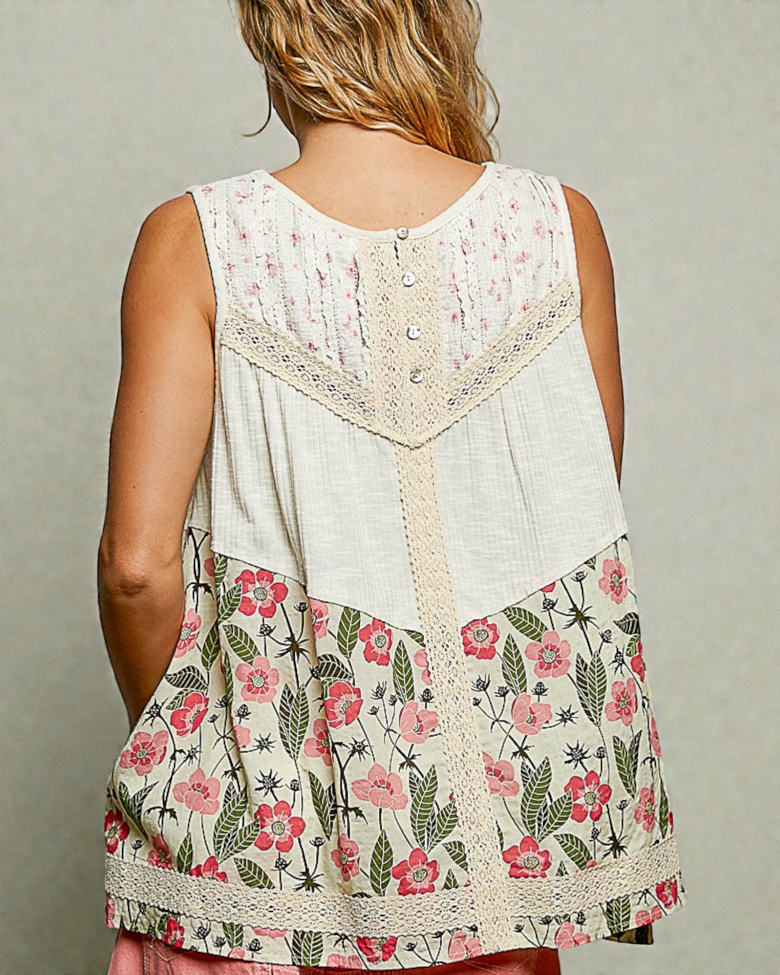 Woman wearing a sleeveless floral top with a neutral background