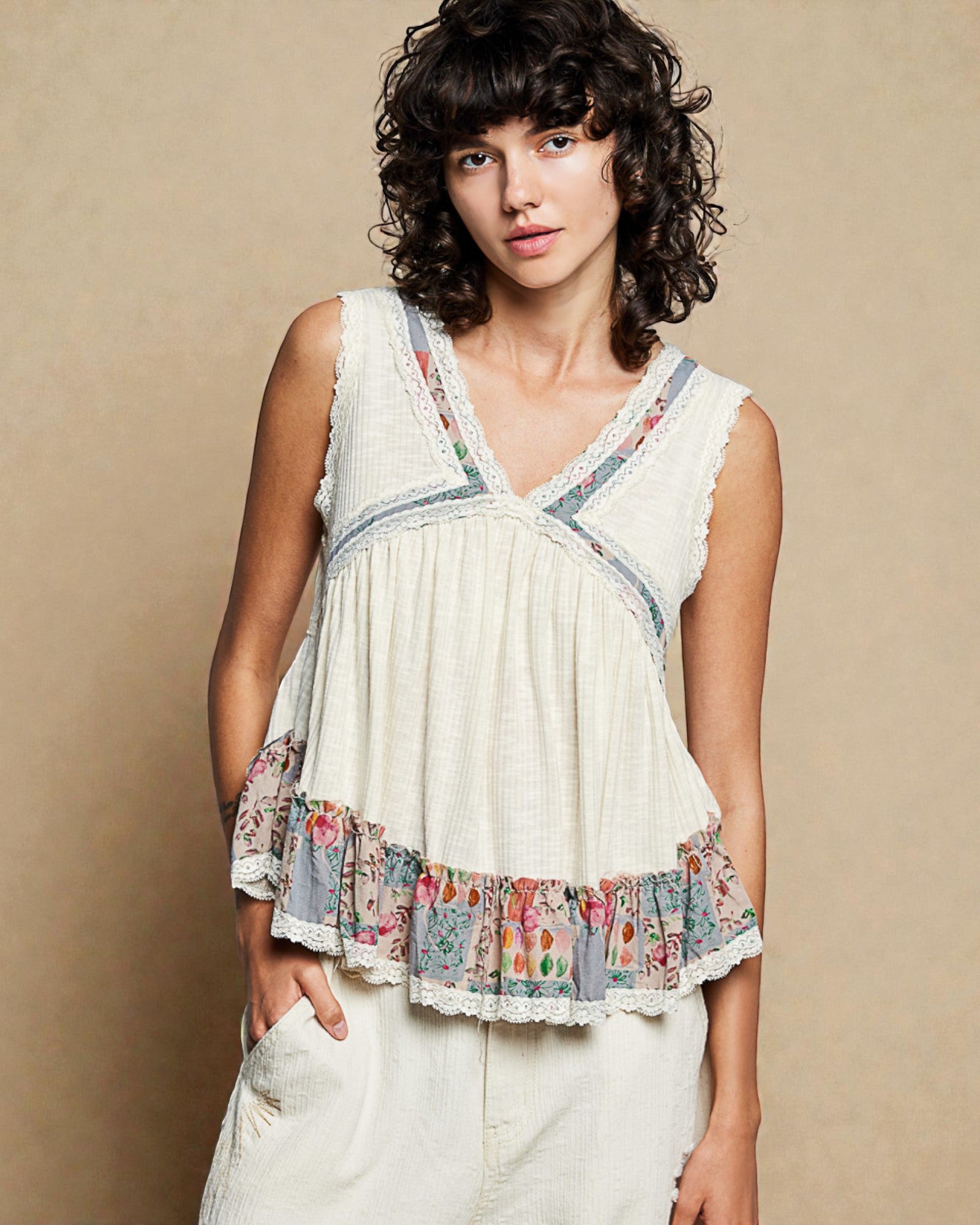 Woman wearing a sleeveless top with floral patterns on a beige background