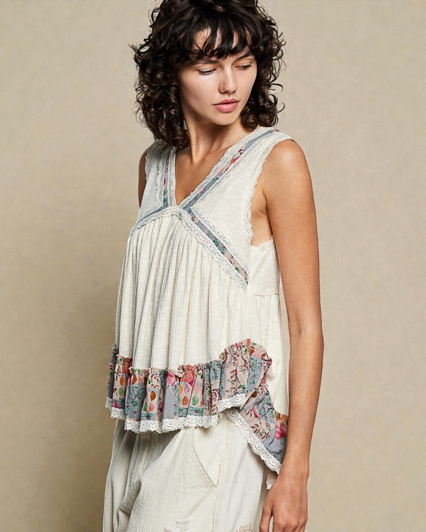 Woman wearing a sleeveless top with floral patterns on a beige background