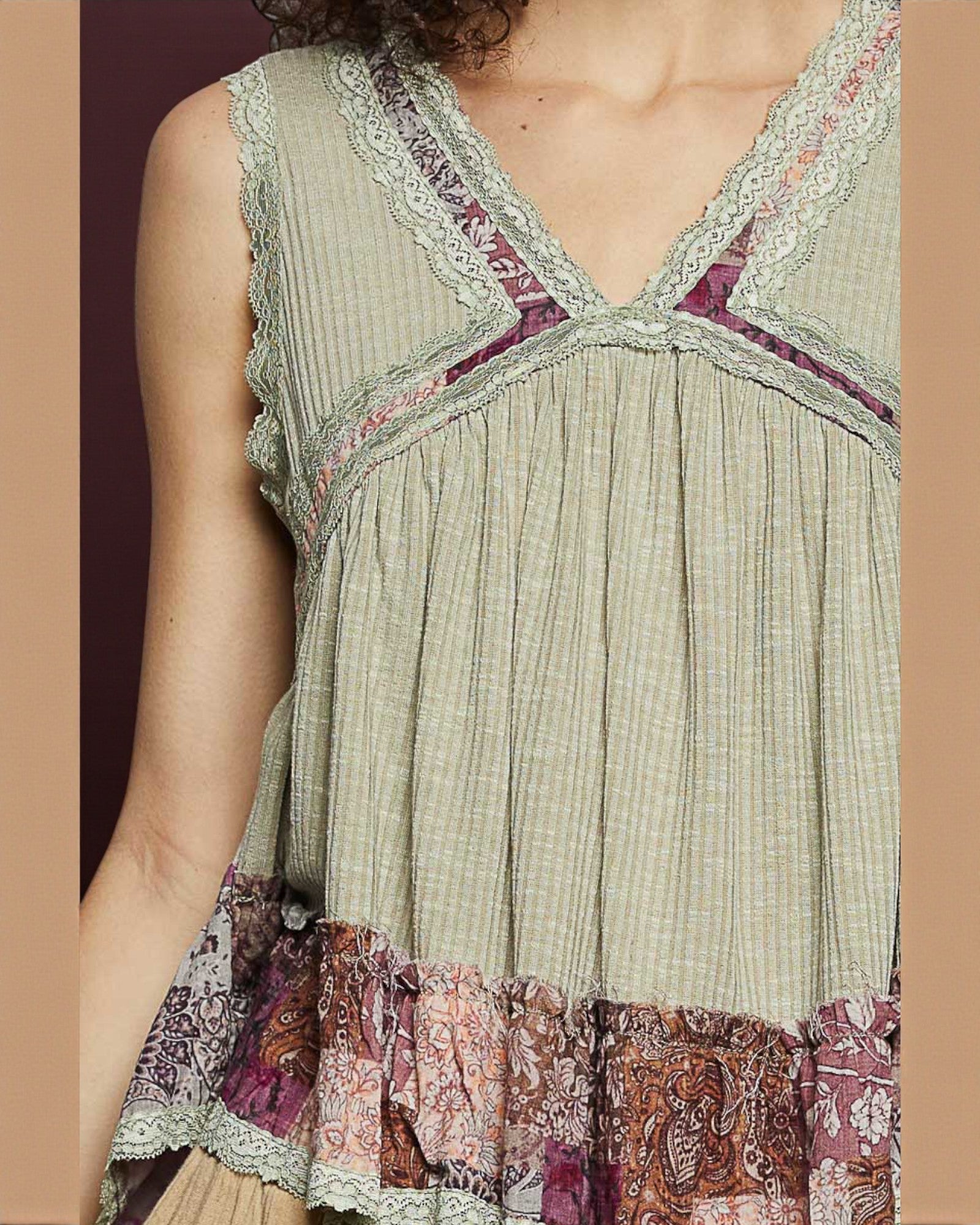 Light green sleeveless top with patterned trim and hem on a plain background