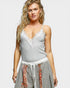 Woman wearing a gray lace top and patterned skirt on a white background
