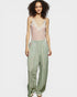 Woman wearing a sheer top and wide-leg pants on a white background