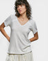 Woman wearing a textured white top against a plain background