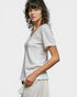 Woman wearing a light gray textured top against a plain background