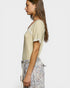 Woman wearing a light-colored top and floral skirt on a white background