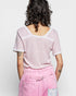 Person wearing a pink textured top and pink pants against a white background