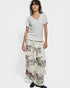 Person wearing a white top and floral layered skirt on a white background
