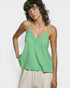 Person wearing a green tank top against a plain background