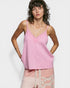 Woman wearing a pink tank top with lace details on a white background