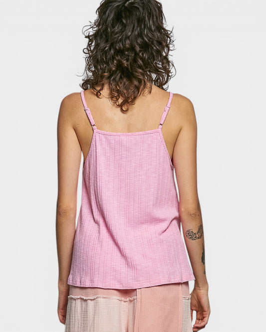 Person wearing a pink tank top and pants on a plain background