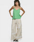 Woman wearing a green top and beige pants with floral embroidery on a white background