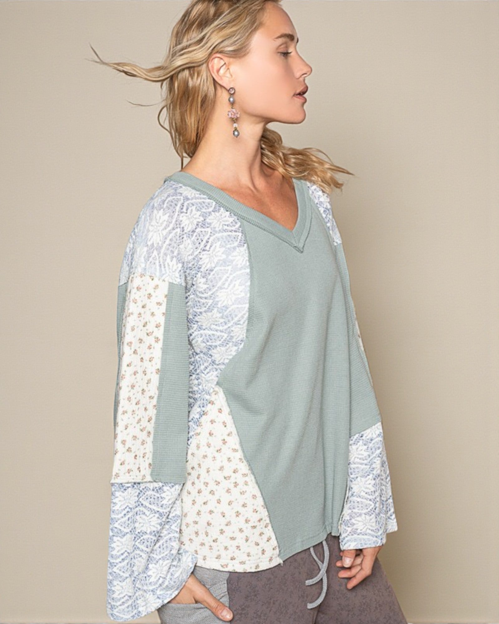 Woman wearing a light green and white patterned top against a beige background