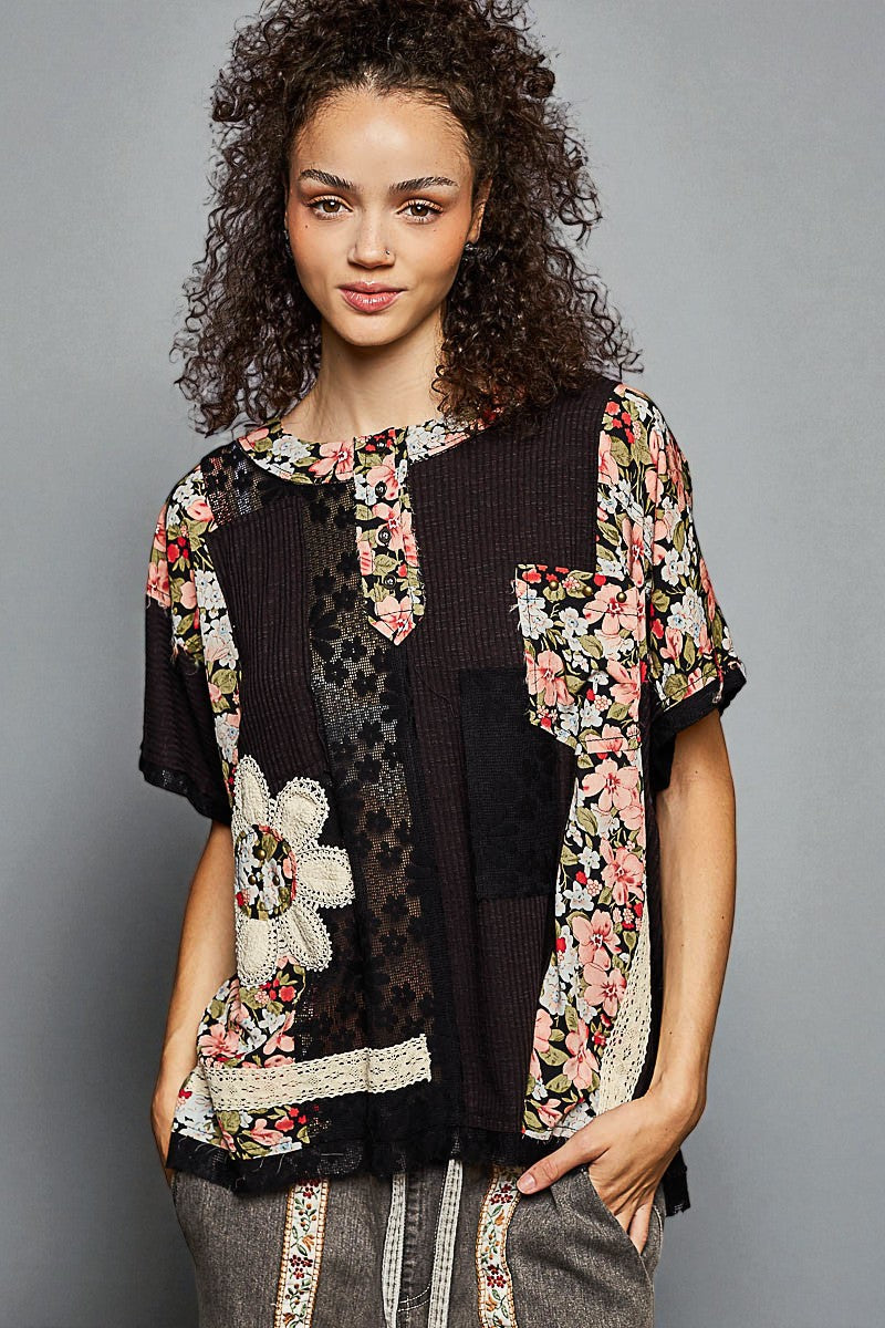 Woman wearing a floral and black patterned outfit against a gray background