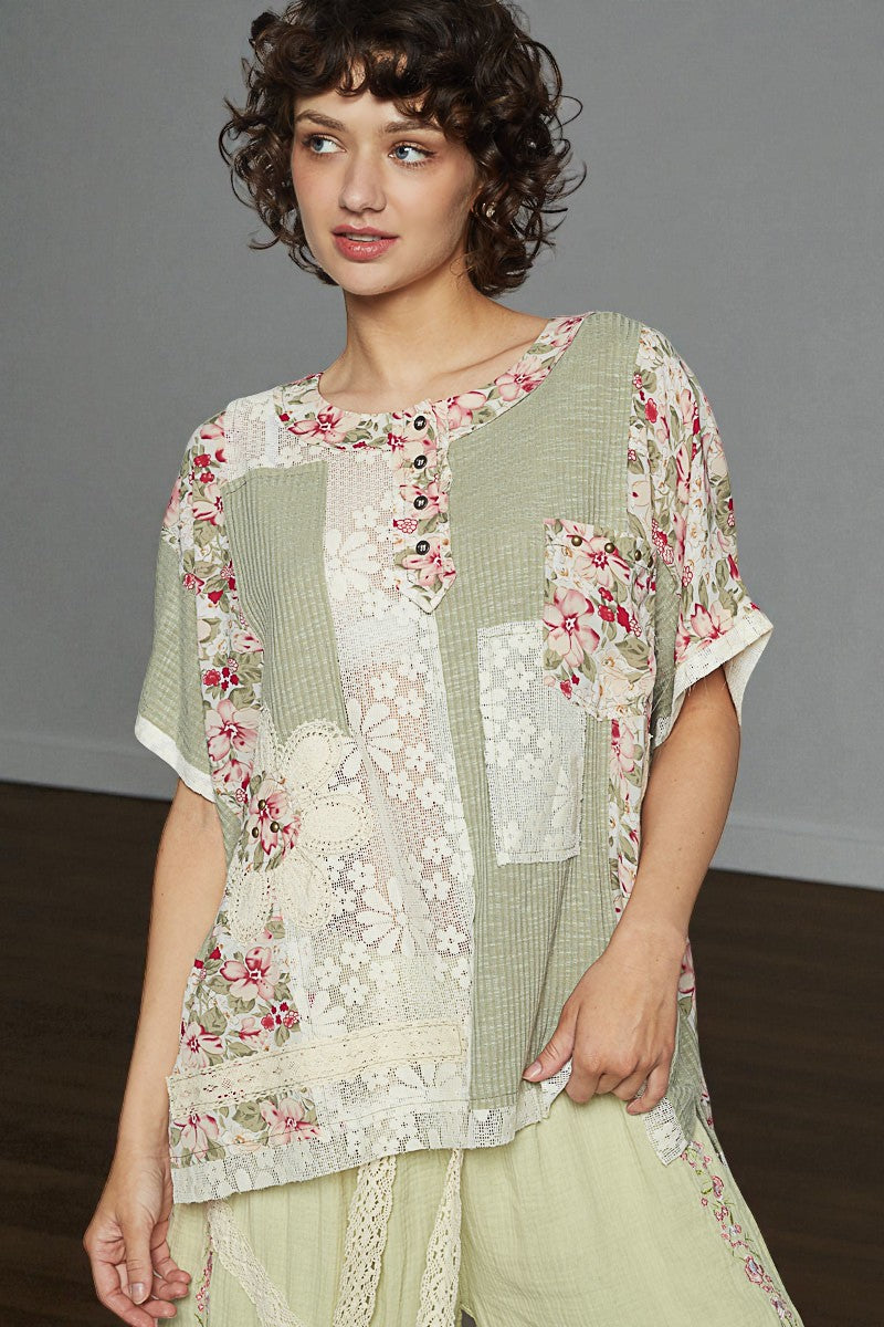 Woman wearing a floral and checkered top with a plain skirt against a gray background