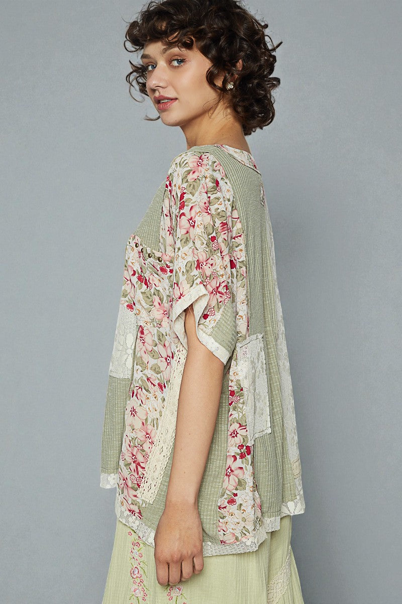 Woman wearing a floral kimono-style garment against a gray background