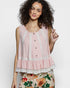 Woman wearing a pink sleeveless top with lace details on a white background