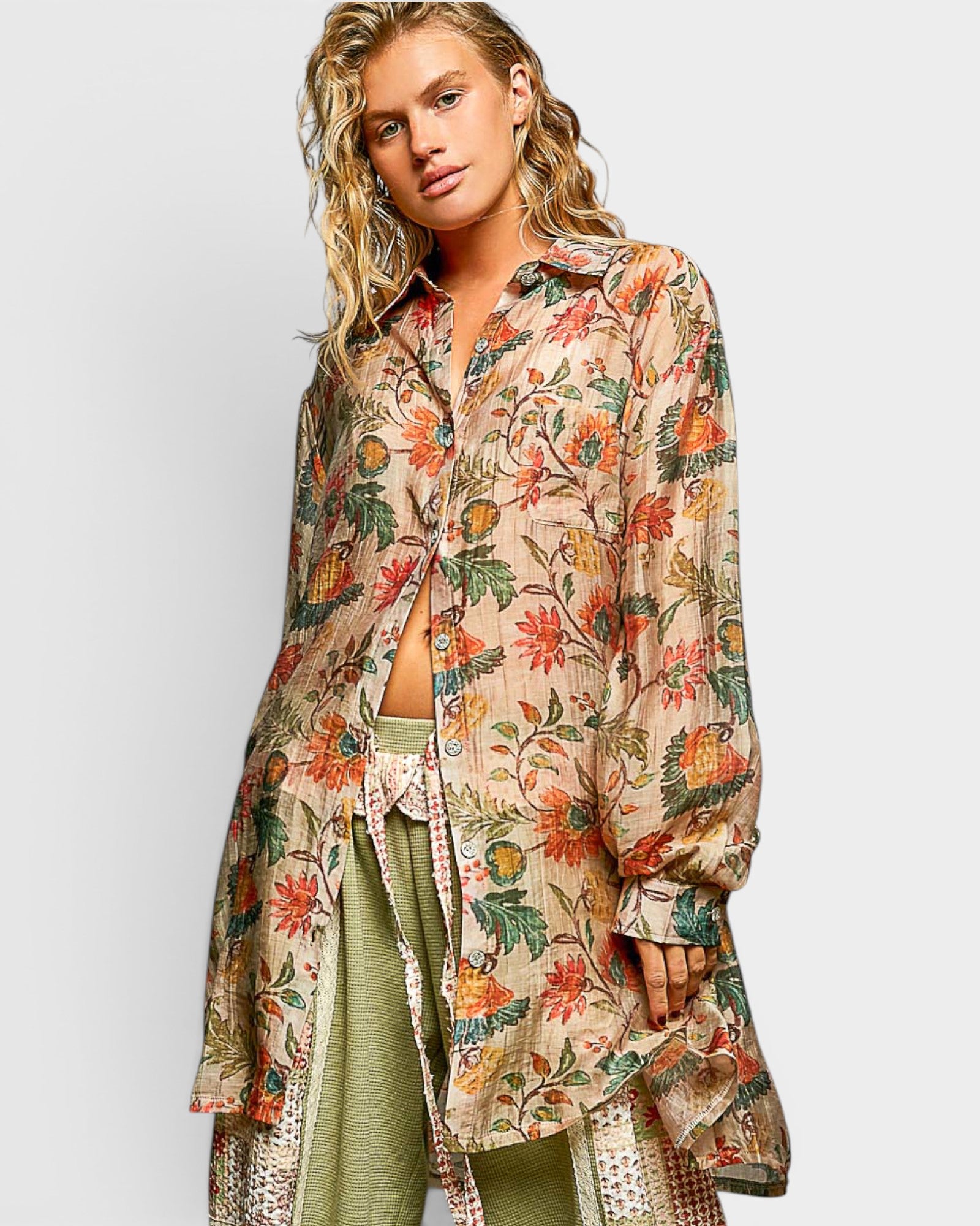 Woman wearing a floral patterned shirt over a green outfit on a white background