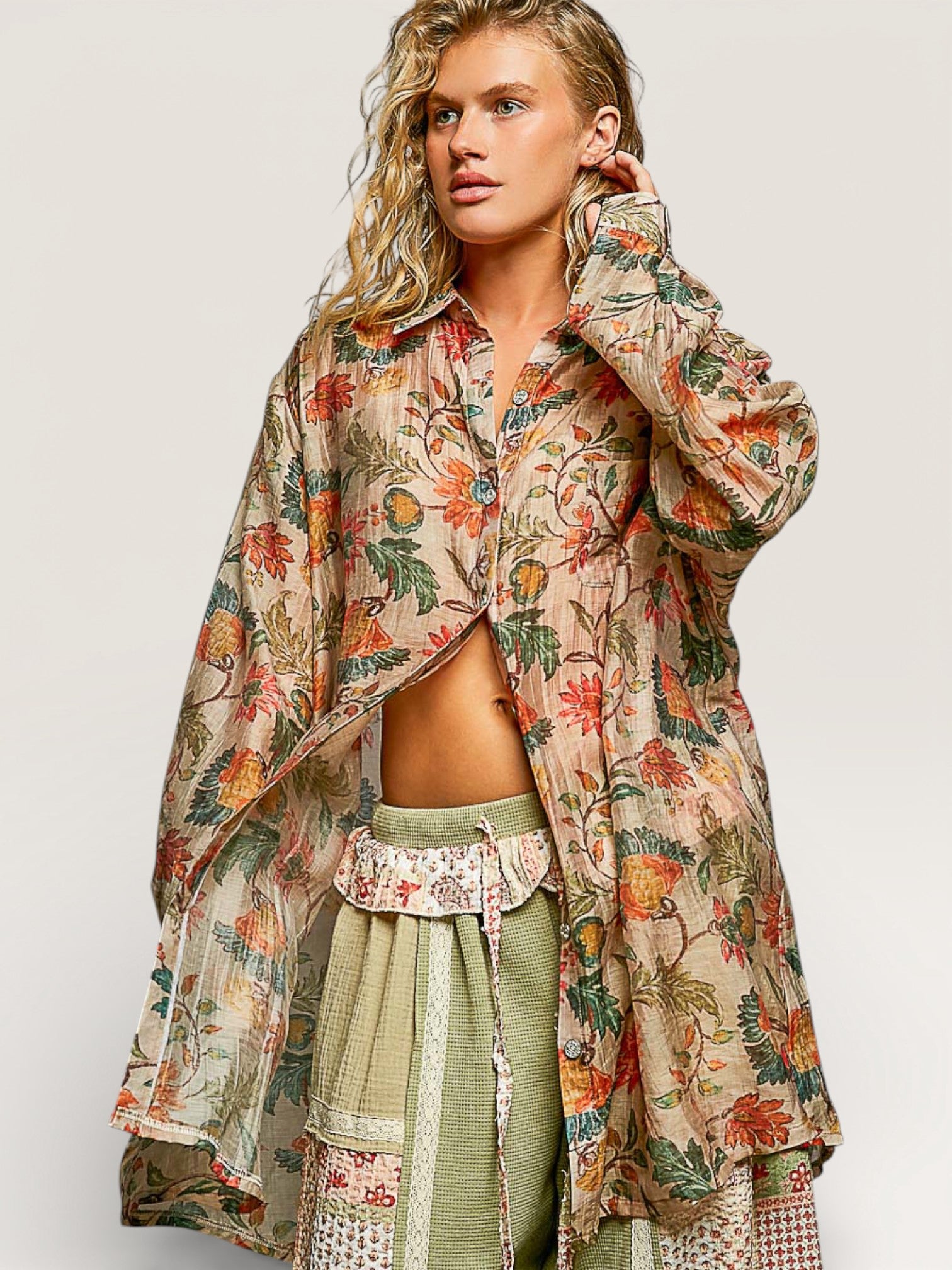 Woman wearing a floral patterned outfit on a plain background