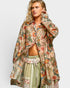 Woman wearing a floral patterned outfit on a plain background
