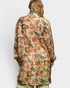 Woman wearing a floral patterned shirt on a white background